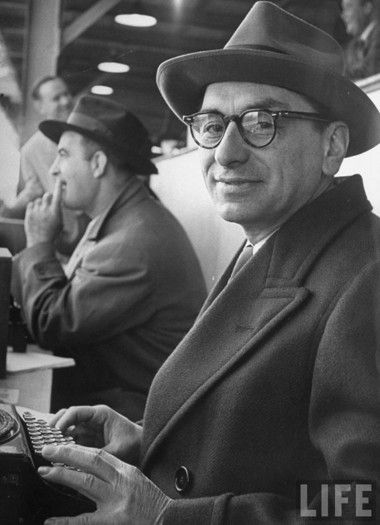 Sportswriter Gus Steiger sitting at typewriter, covering the Army-Navy game